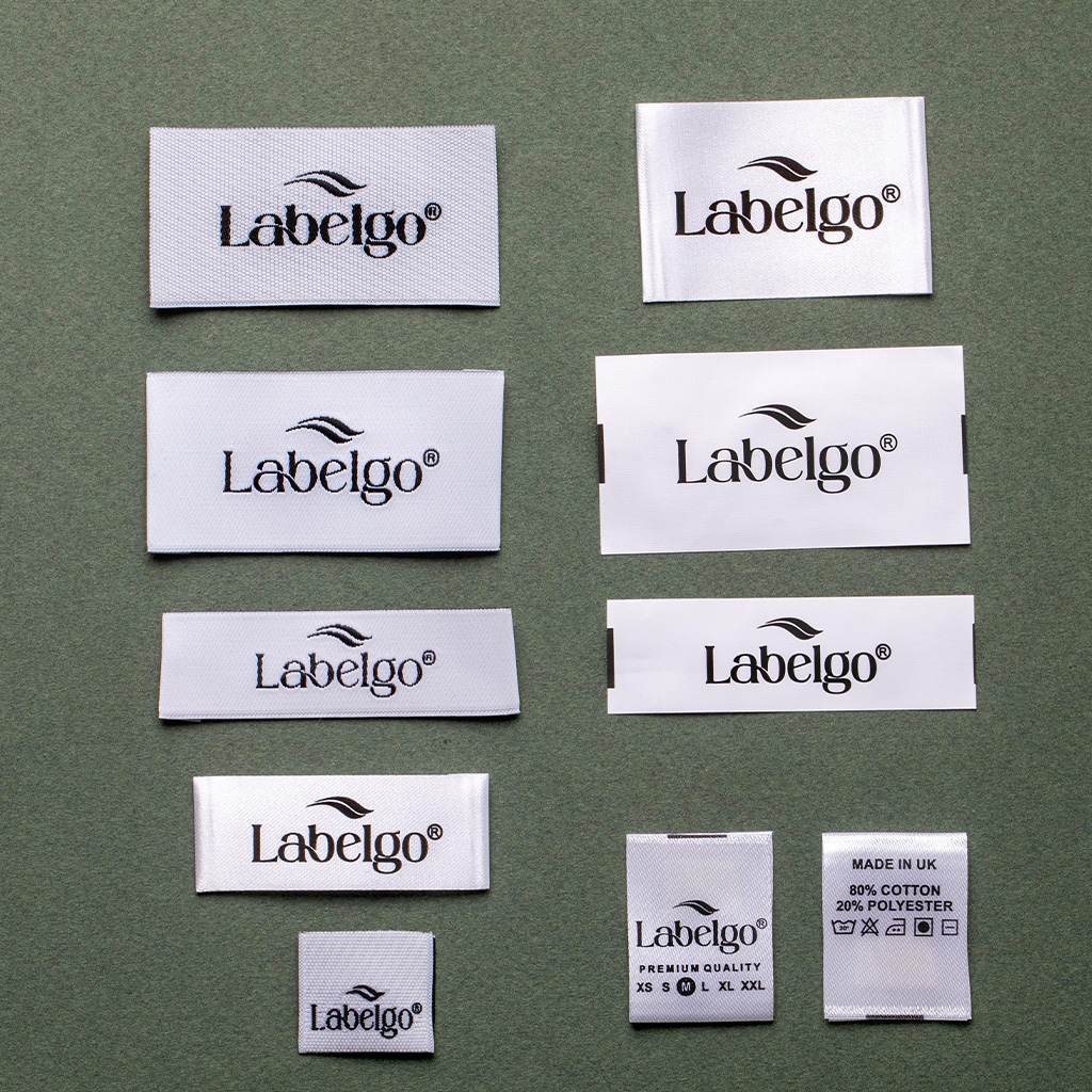 White woven fabric labels with LabelGo logo on grey surface.