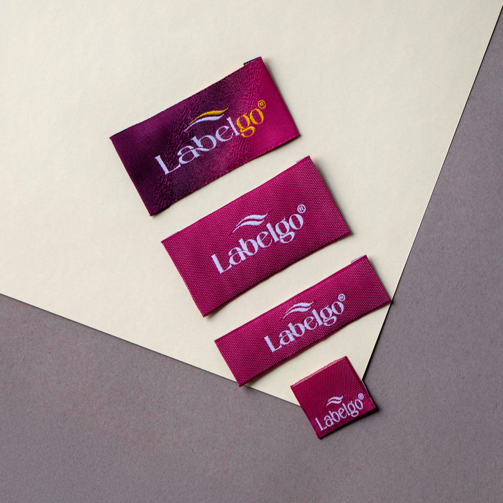 Burgundy woven labels placed on beige background.